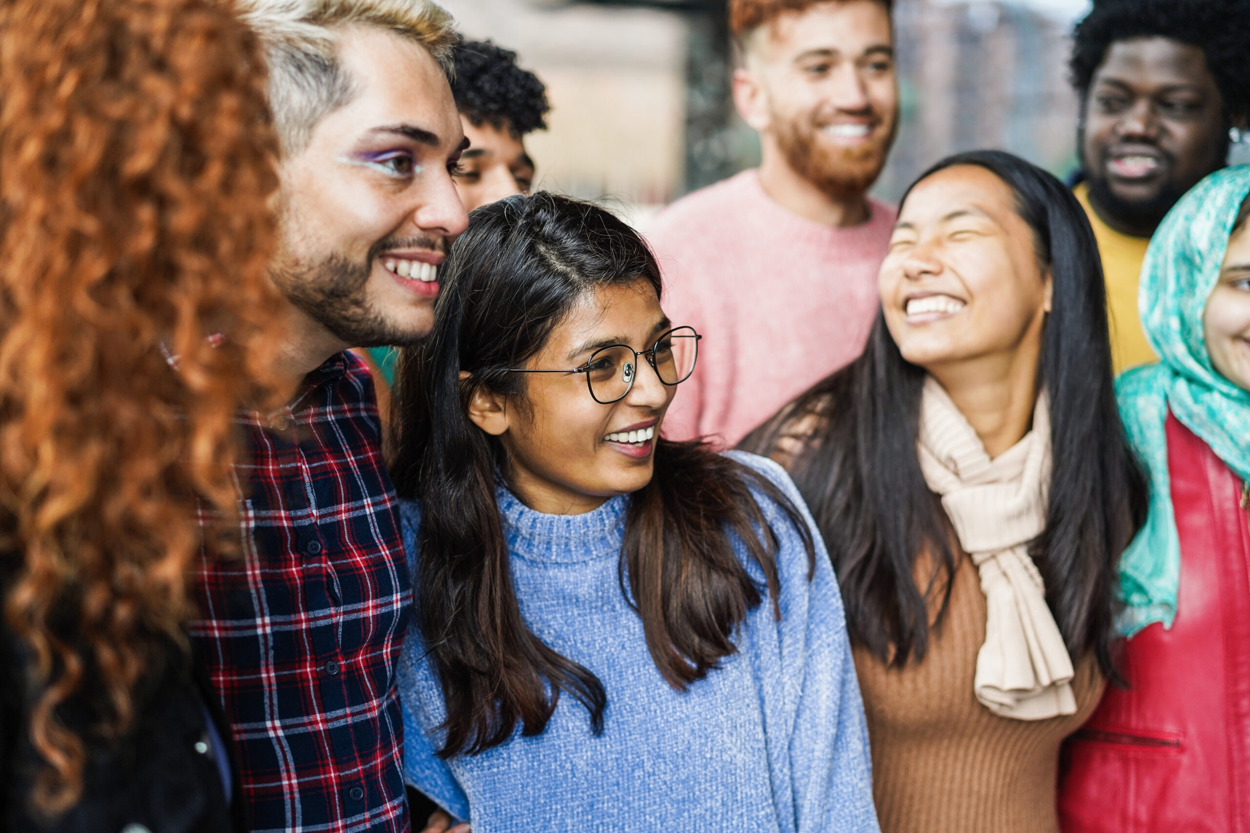 Young diverse people having fun outdoor laughing together – Focus on indian girl face